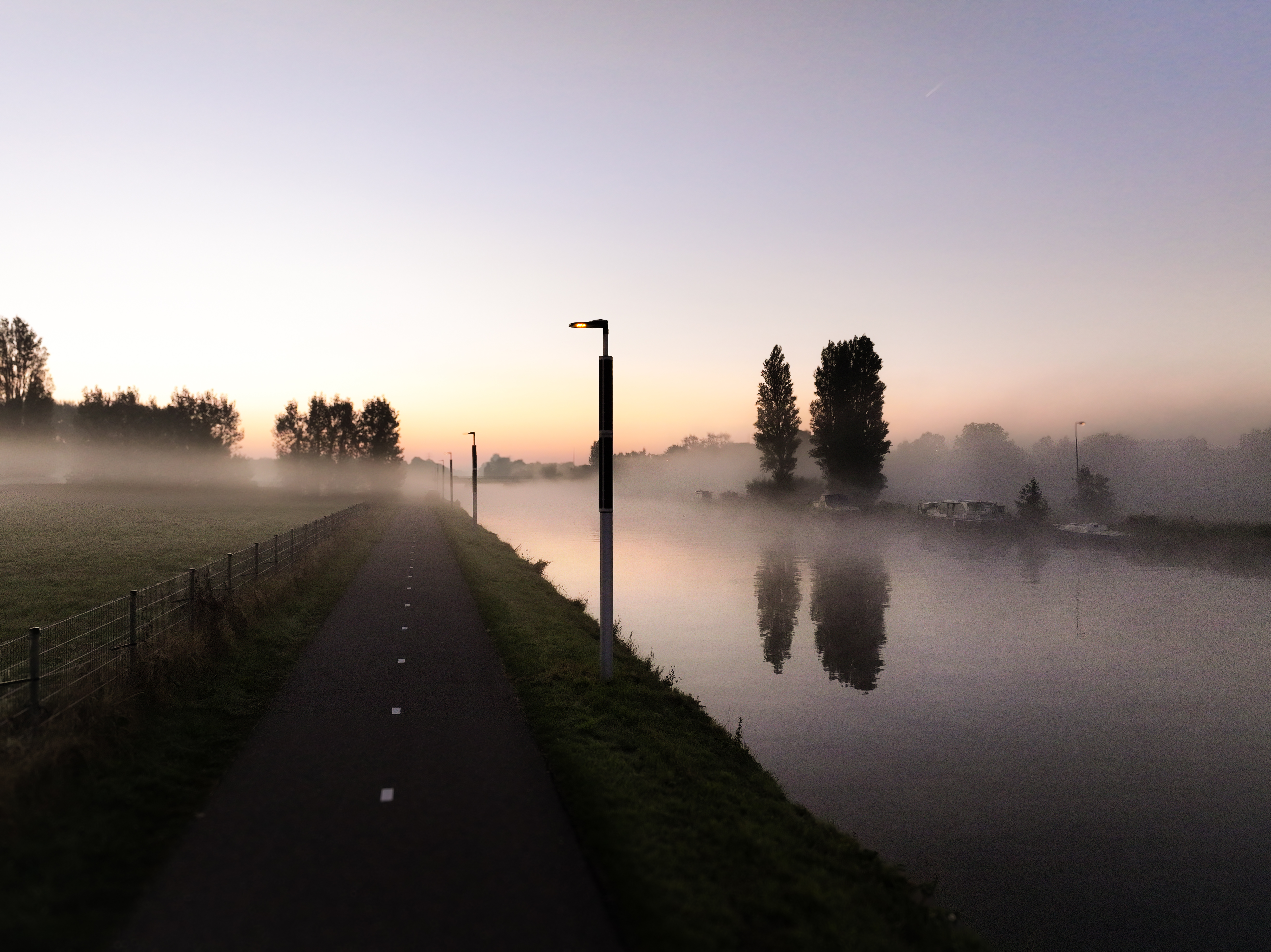 Soluxio solarverlichting langs een kanaal met NatureGuard amberkleurige verlichting Soluxio Lighting NatureGuard solar pole with amber ecological lighting along canal and bicycle path in Katwijk, The Netherlands
